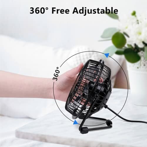 Hand adjusting a 360-degree free adjustable desk fan.