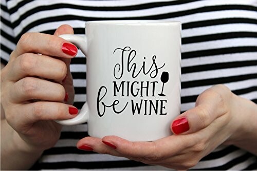 Man in blue robe dipping cookie in mug labeled 'This Might Be Wine'.