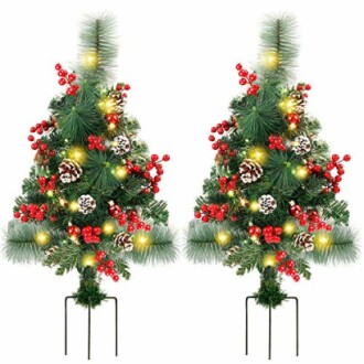 Two decorated artificial Christmas topiary trees with lights and berries