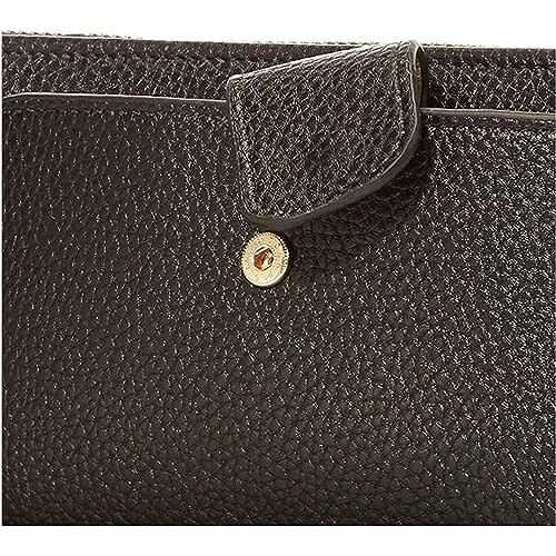 Close-up of a black textured leather bag with a button closure, showcasing the high-quality materials used in this wristlet wallet