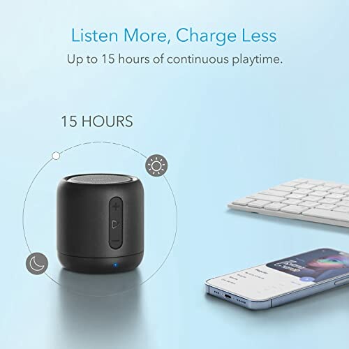Portable Bluetooth speaker with 15-hour playtime shown next to smartphone and keyboard.