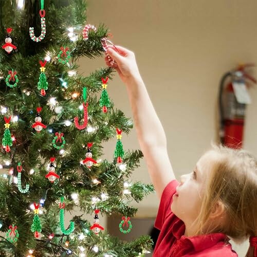 Child decorating a Christmas tree with ornaments.