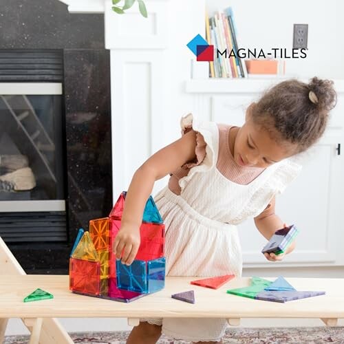 Child playing with colorful Magna-Tiles on a wooden bench.