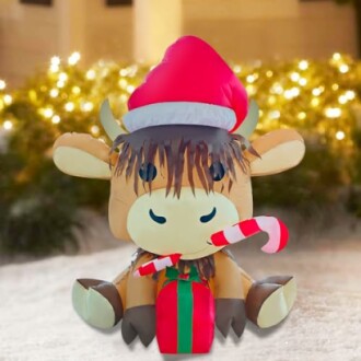 Inflatable cow with Santa hat and candy cane.