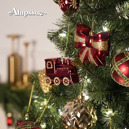 Christmas tree with red and gold ornaments including a train and bow.