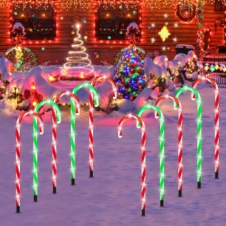 Festive yard with candy cane lights and colorful Christmas decorations.