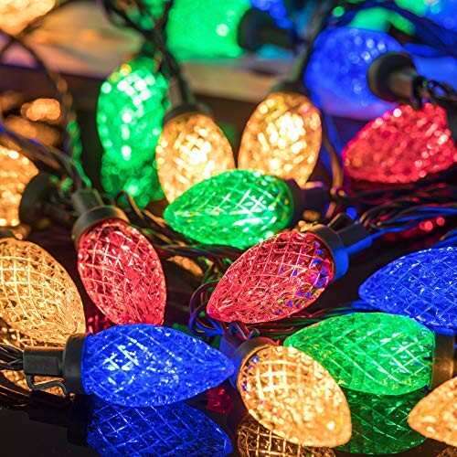 Colorful Christmas string lights on a dark surface.