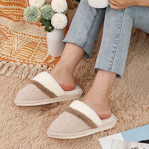 Person wearing cozy slippers on a rug, holding a mug.