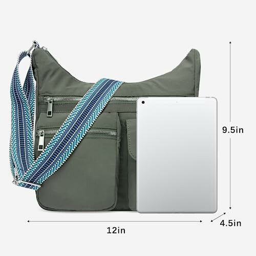 Gray crossbody bag with blue strap and tablet for size reference.