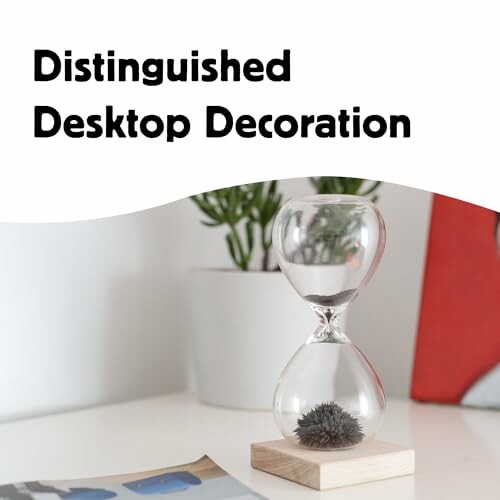 Hourglass on desk with plant in background
