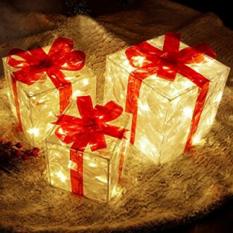 Three illuminated gift boxes with red ribbons.