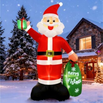 Giant inflatable Santa Claus with gift and Merry Christmas bag in snowy yard.