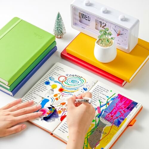 Person journaling with colorful notebooks and a clock.