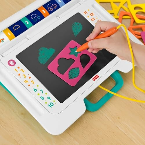 Child using a drawing tablet with a stencil to trace shapes.