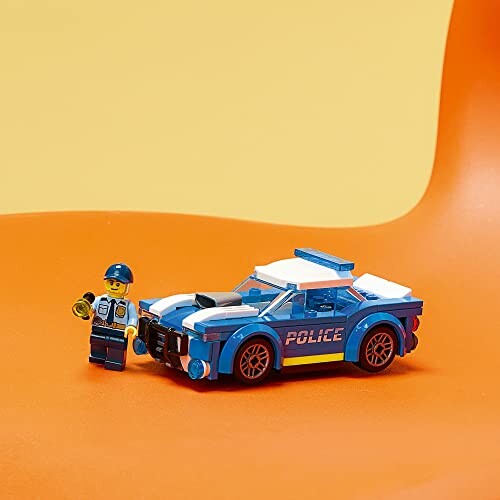Lego police car with figure on orange background.