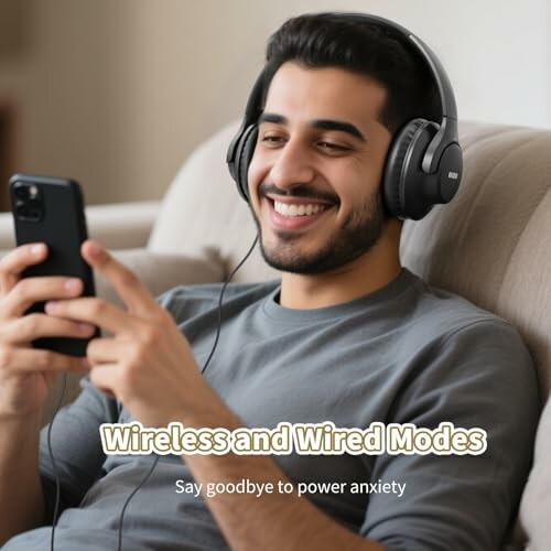 Man smiling with headphones using a phone.