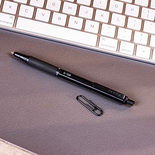 Mechanical pencil and paperclip on a desk near a keyboard.