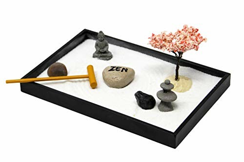 Mini Zen garden with sand, stones, rake, and miniature tree.