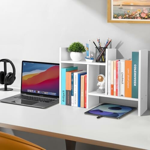 Tidy desk with laptop, books, and accessories.
