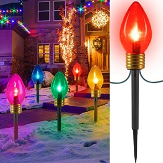 Colorful Christmas light stakes illuminating a snowy yard.