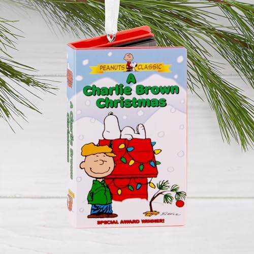 A Charlie Brown Christmas ornament hanging on a pine branch.