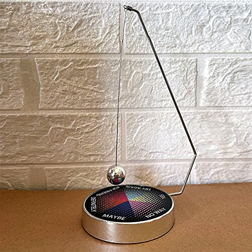 Magnetic Decision Maker Swing Pendulum on a table with options like yes, no, maybe