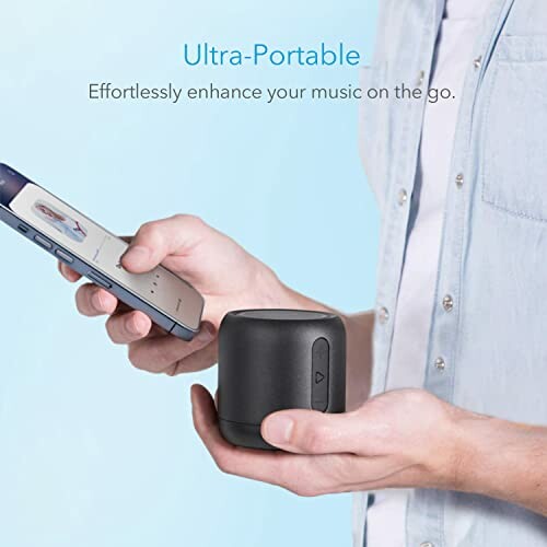 Person holding a smartphone and portable Bluetooth speaker.