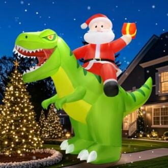 Inflatable Santa riding a green dinosaur in front of a house decorated with Christmas lights.
