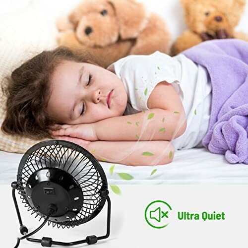 Child sleeping peacefully with a fan nearby