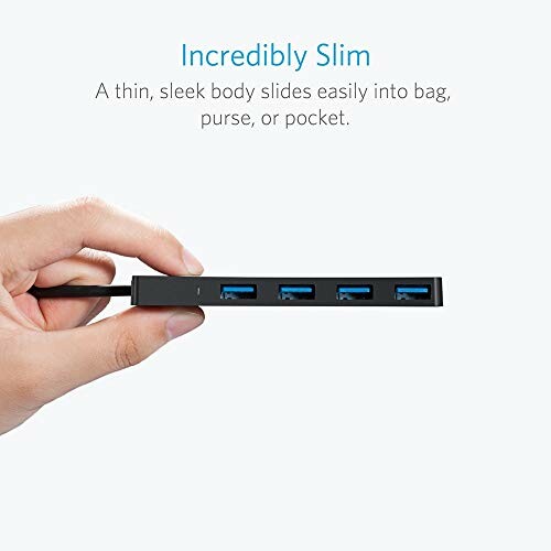 Hand holding a slim USB hub with four ports.
