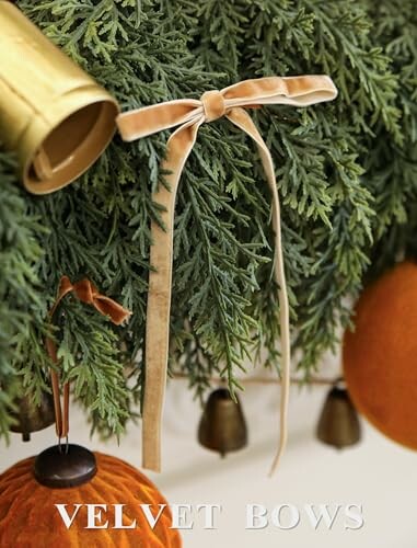 Velvet bows on Christmas greenery with bells and ornaments.