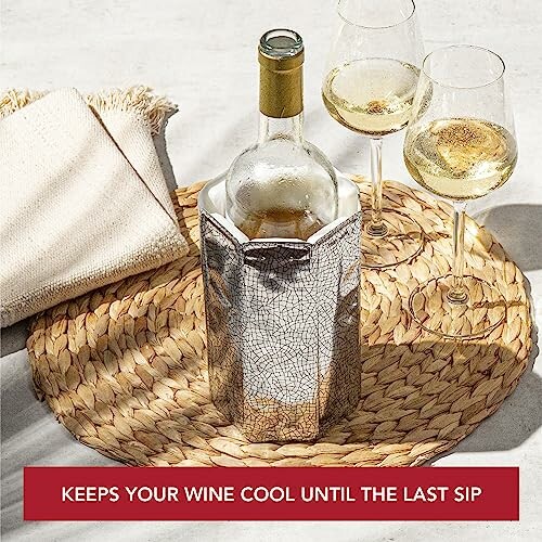 Wine bottle in cooler with two glasses on woven mat.