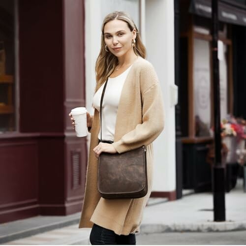 Woman holding coffee cup with brown crossbody bag. The perfect accessory for a busy lifestyle.