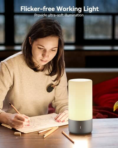 Woman drawing by a flicker-free desk lamp.