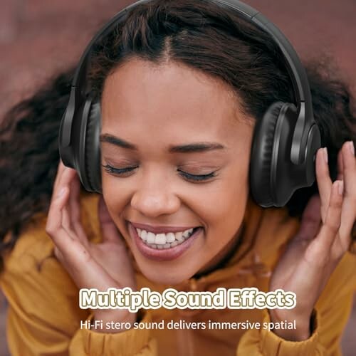 Woman smiling with headphones enjoying music.