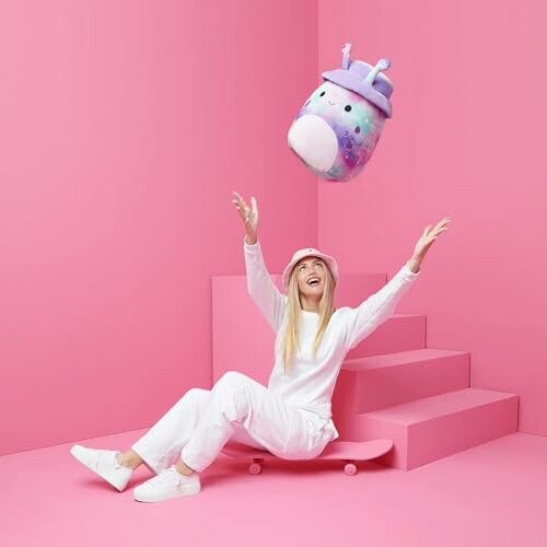 Woman in white throwing colorful unicorn plush toy in pink room, but in this case, it's a purple alien plush toy.